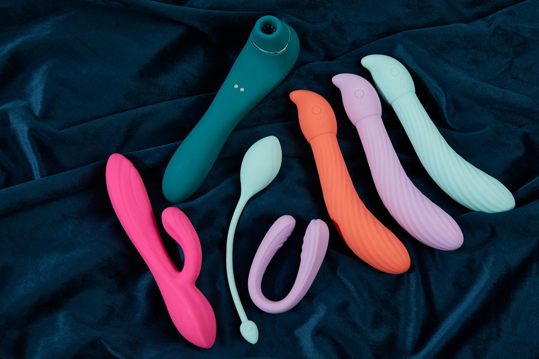 Couple standing together indoors holding a blue vibrator, symbolizing modern intimacy and partnership.