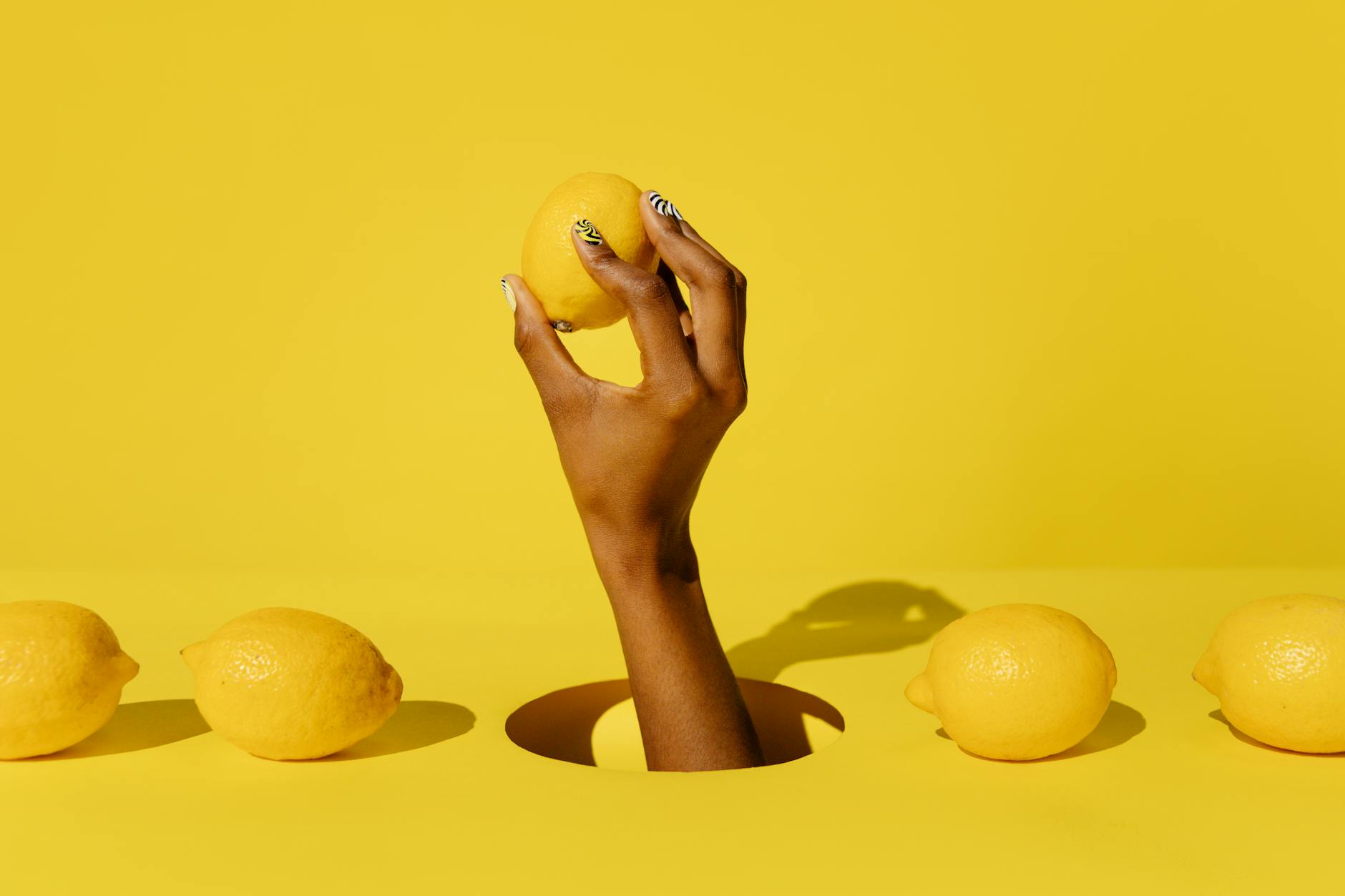 Woman holding lemon clitoral vibrators against a purple background