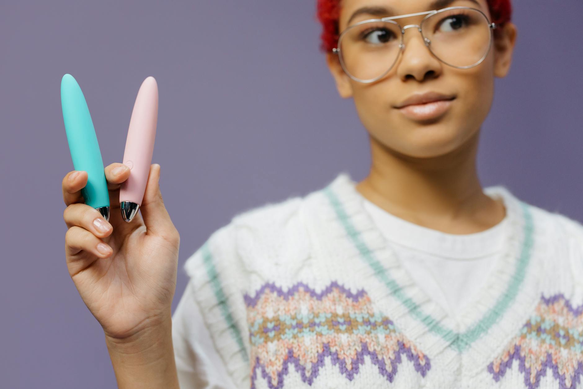 Woman holding lemon clitoral vibrators with contemplative expression