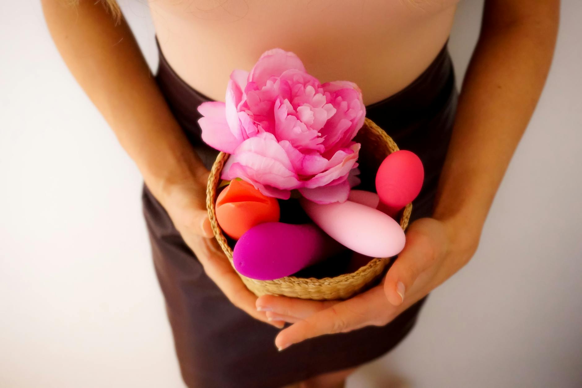 A pink vibrator on a purple background with heart confetti and candles for a romantic vibe